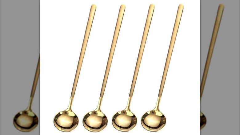 Four stainless steel stirring spoons are in a line