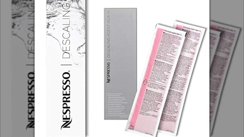 A Nespresso cleaning kit with two pouches and instructions is shown