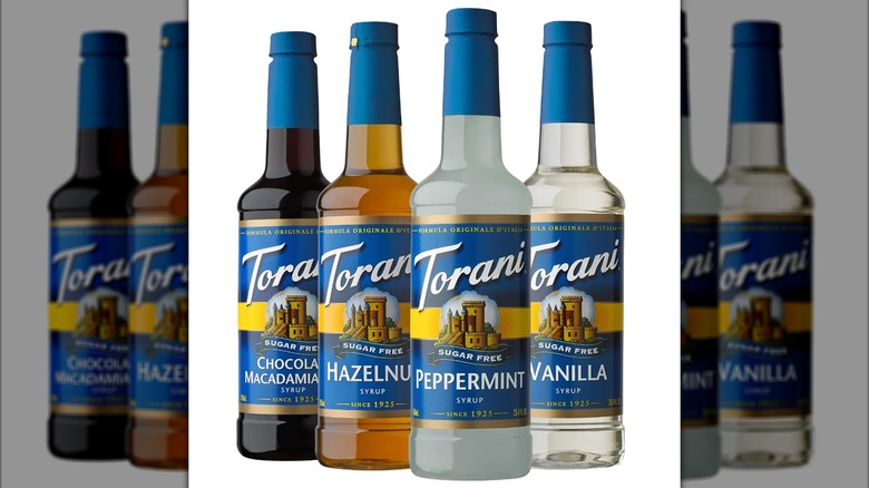 A variety pack of Torani coffee syrup is shown in a line