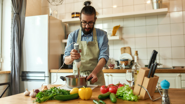 Man using immersion blender.