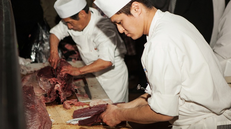 Japanese chefs cut raw meat