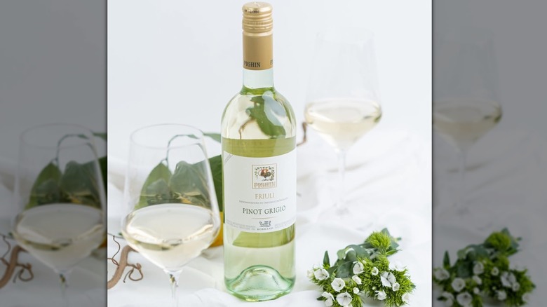 Bottle of Pighin pinot grigio with glass and flowers