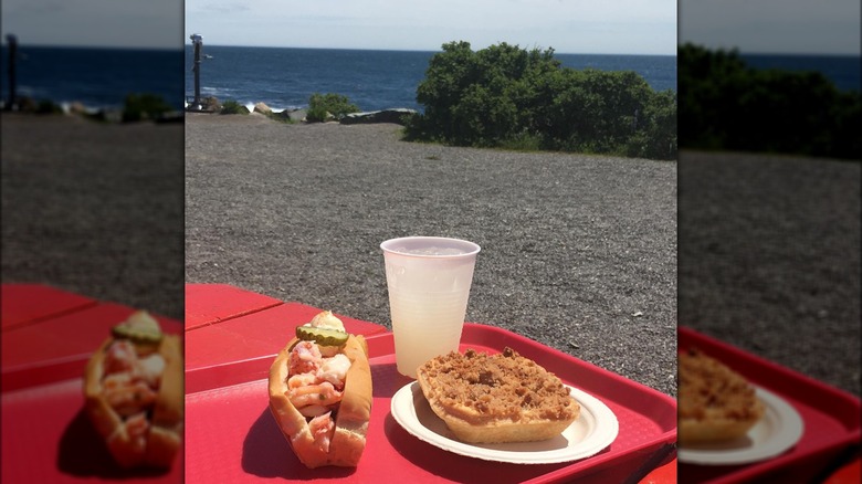 Lobster roll, blueberry pie, and icy lemonade assembled on a table