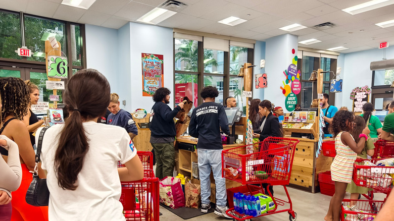 Lots of people standing in line with red carts at Trader Joe's