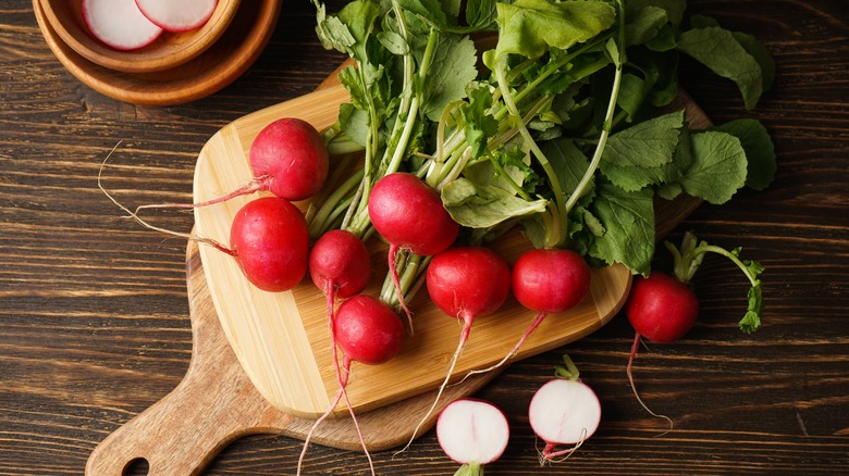 Red radishes on cutting board