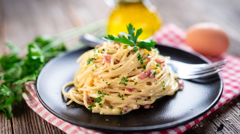 Spaghetti carbonara on black plate