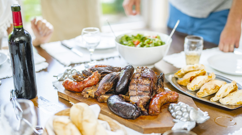 table with grilled meat and wine