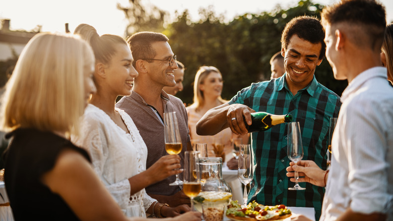 pouring sparkling wine at gathering