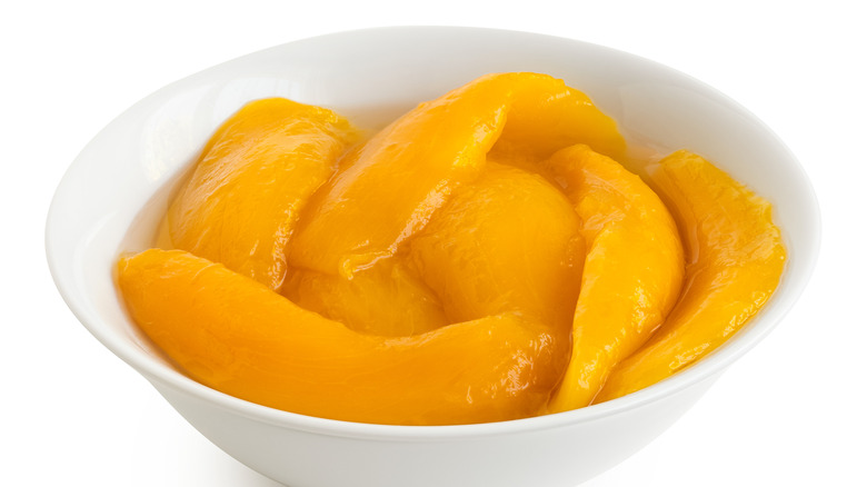 Canned mango slices in white bowl