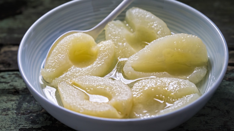 Bowl of canned pear halves with spoon