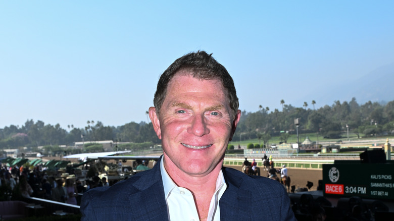 Bobby Flay smiling at a horserace