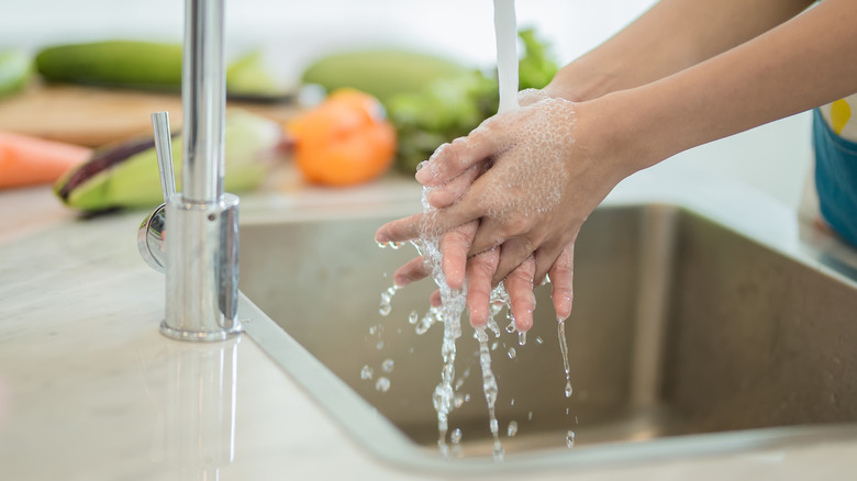 Sink water splashing over hands