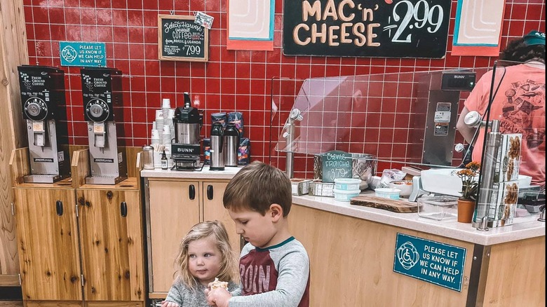 Two children standing in front of sample table at Trader Joe's