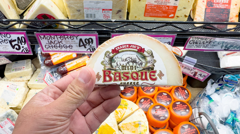 A person holdng a block of cheese at Trader Joe's