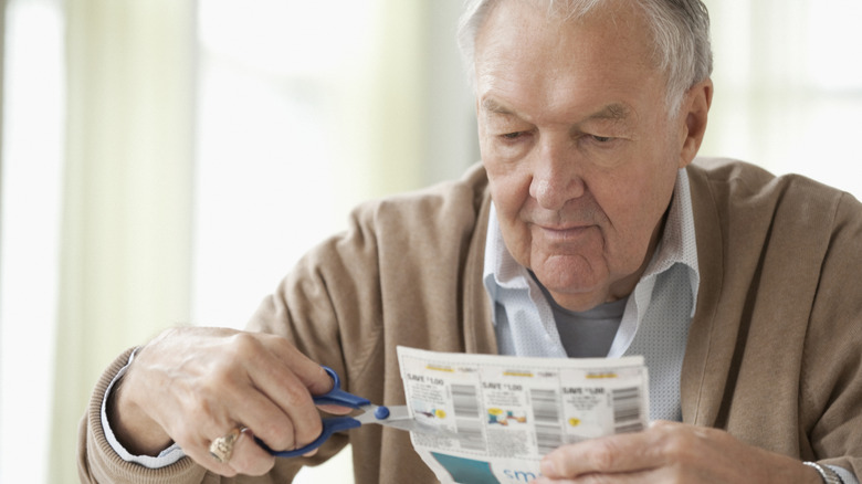 A man clippping coupons