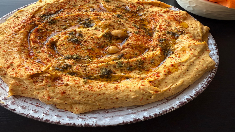 Plate of hummus with seasonings and oil