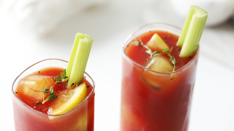 Two bloody mary cocktails with celery stick garnishes