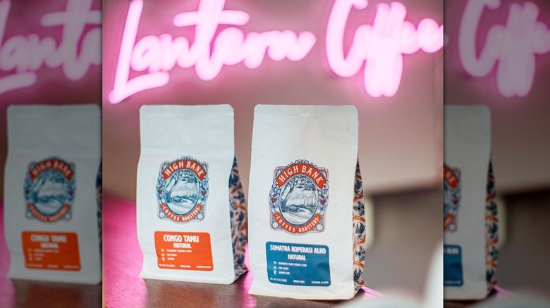bags of coffee on table with neon sign
