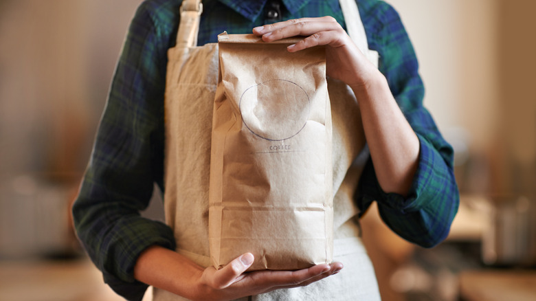 barista holding bag of coffee