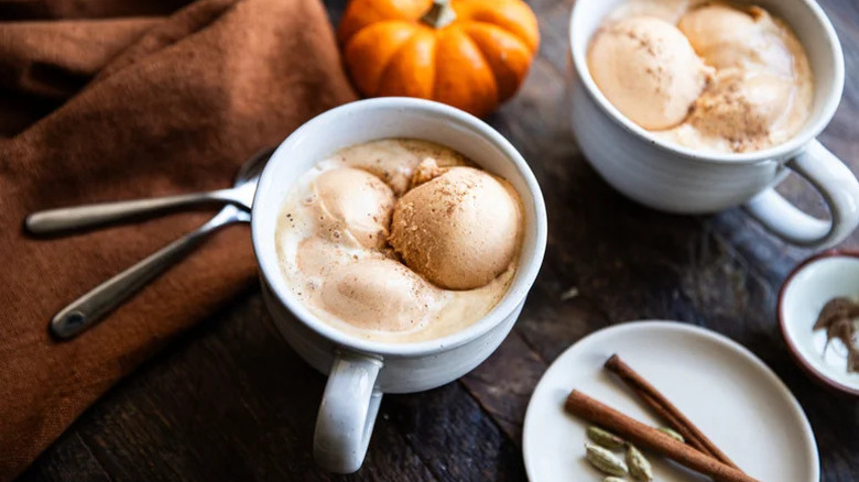 Decadent pumpkin spice affogato on table with pumpkin and cinnamon sticks