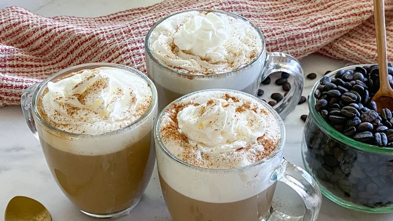 Homemade café latte in mugs on white countertop