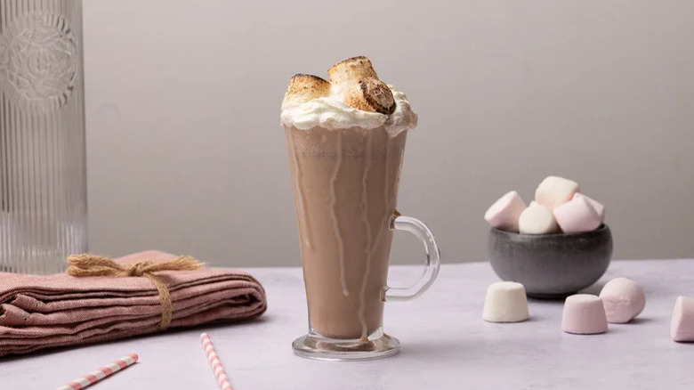 Toasted marshmallow coffee milkshake in glass with marshmallows in background