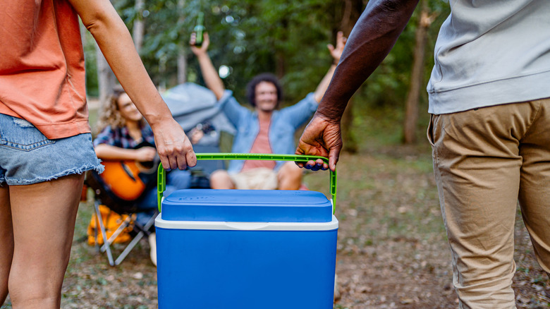 Two people holding a cooler