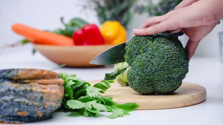 Chef cutting broccoli stem