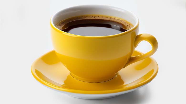 Yellow cup of black coffee