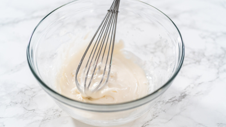 Glaze in a clear bowl with a whisk