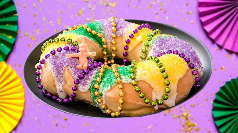 King cake decorated for Mardi Gras with a plastic baby decoration