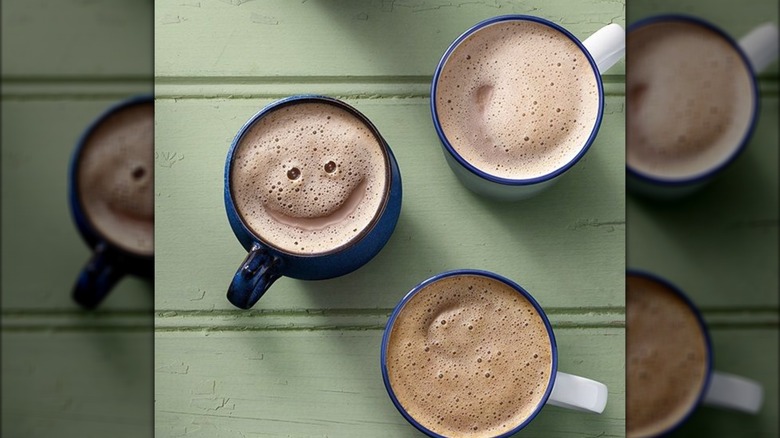 Three cups of hot chocolate on a green table