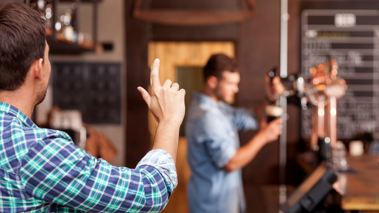 man ordering drink at a bar