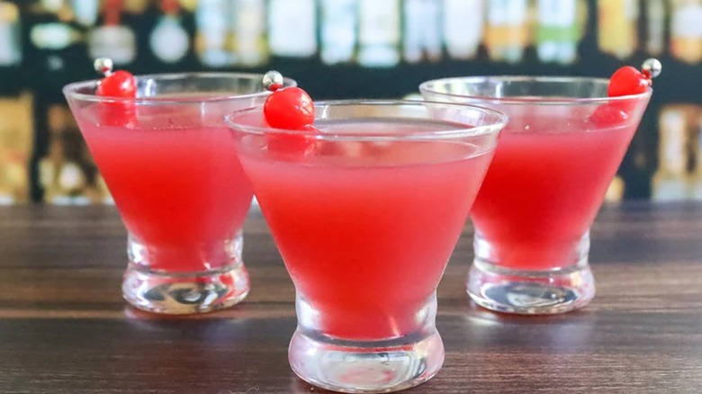 three bright colored cocktails with cherry filled toothpicks