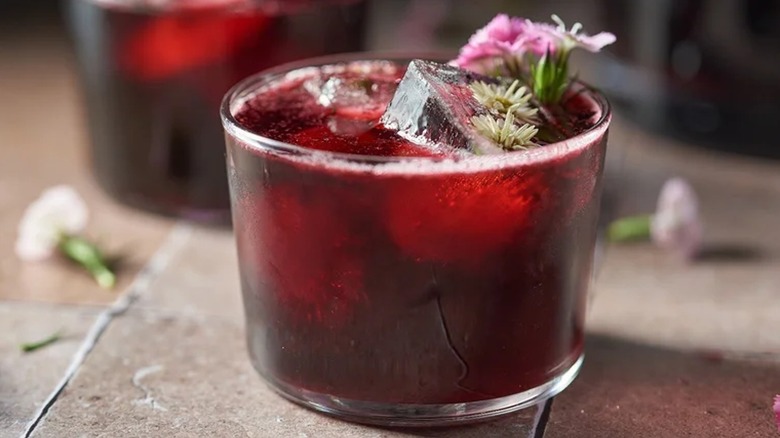 glass of hibiscus tea with hibiscus flowers on top