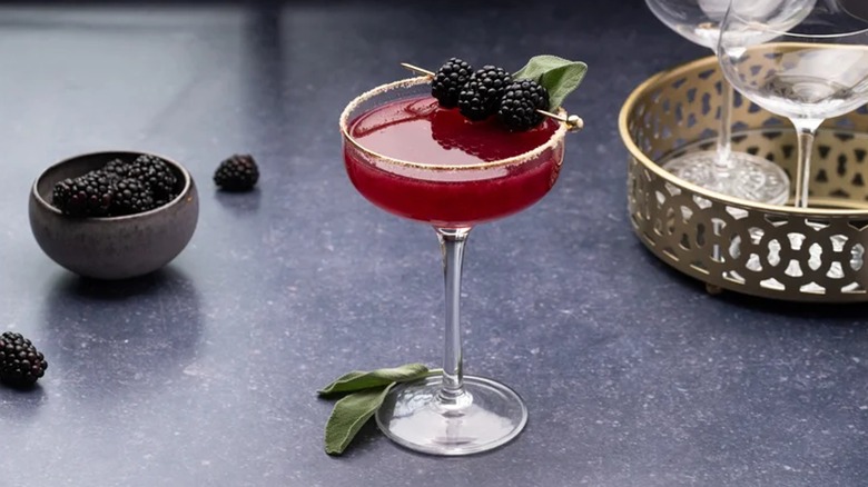 blackberry sage margarita on table with bowl of blackberries on the side