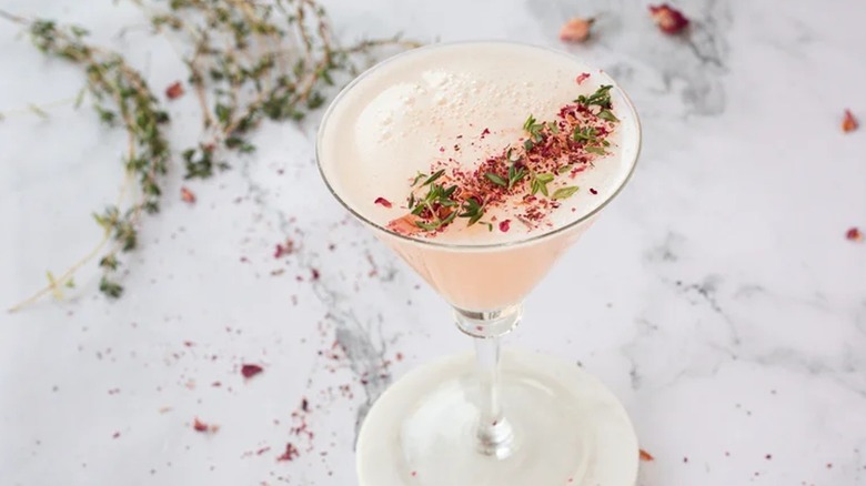 Floral negroni in a martini glass on marble surface