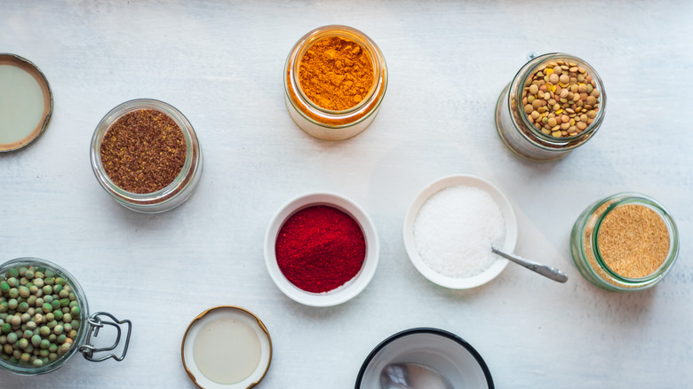 Spices and lentils in jars on white backgroun