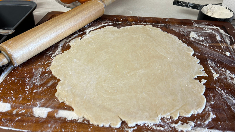 Rolling out a pie crust on a surface with rolling pin