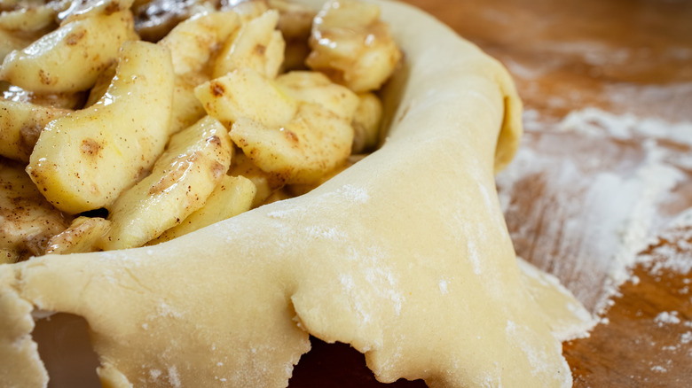 Apple pie with crust overflowing over the edges