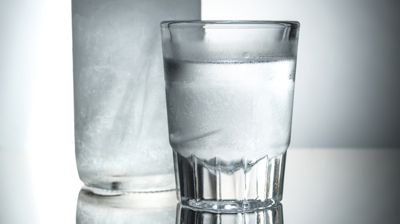 Vodka in a glass with bottle in the background