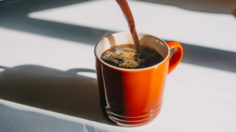 A standard mug of coffee being poured