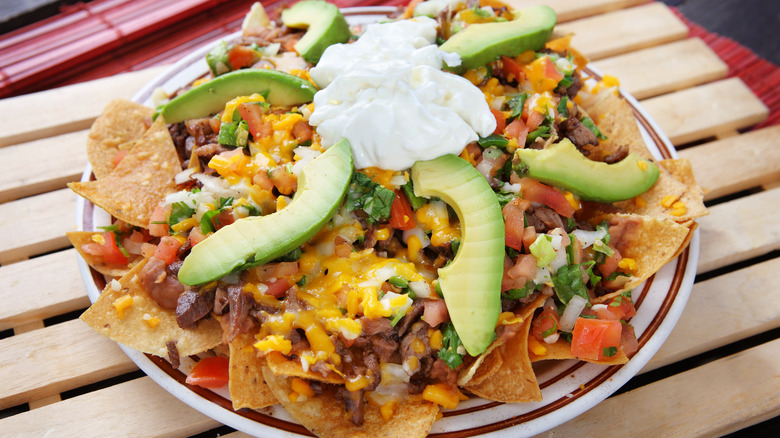 Plate of nachos on wooden table 