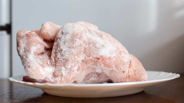 Frozen chicken thawing on plate