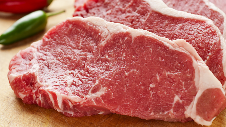 Raw steak on wooden board 