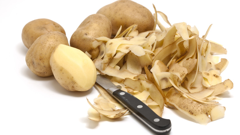 Potato peels next to potatoes 