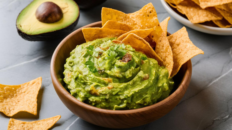 fresh guacamole in bowl with chips