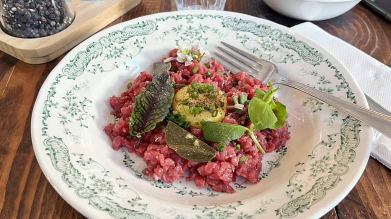 steak tartare on white dish with fork