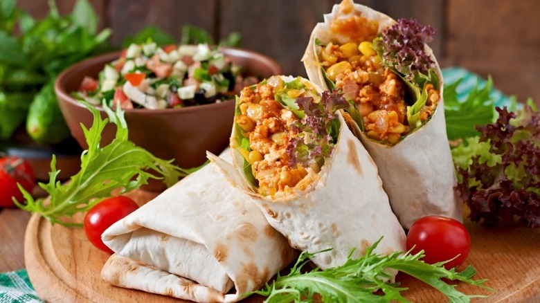 Three burritos on a cutting board