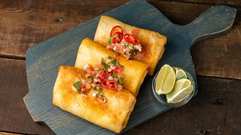 Three chimichangas with limes